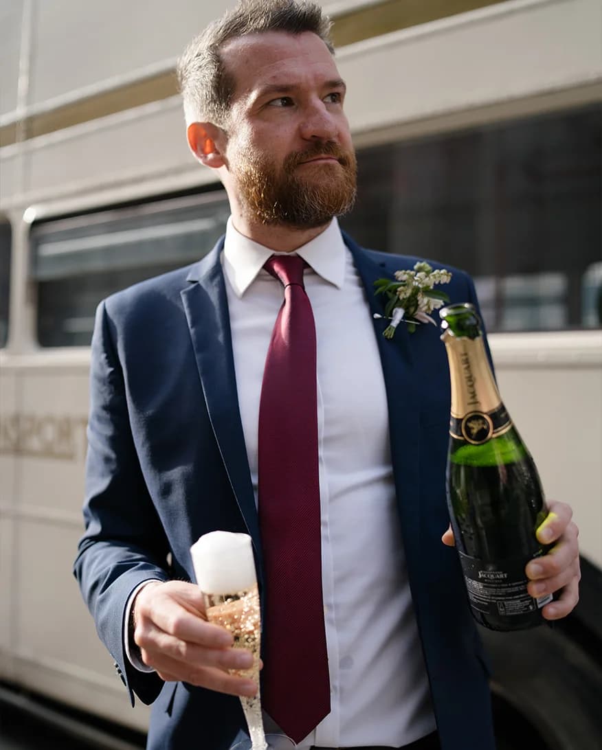 A wedding guests pours a Jacquart  champagne from a bottle. 