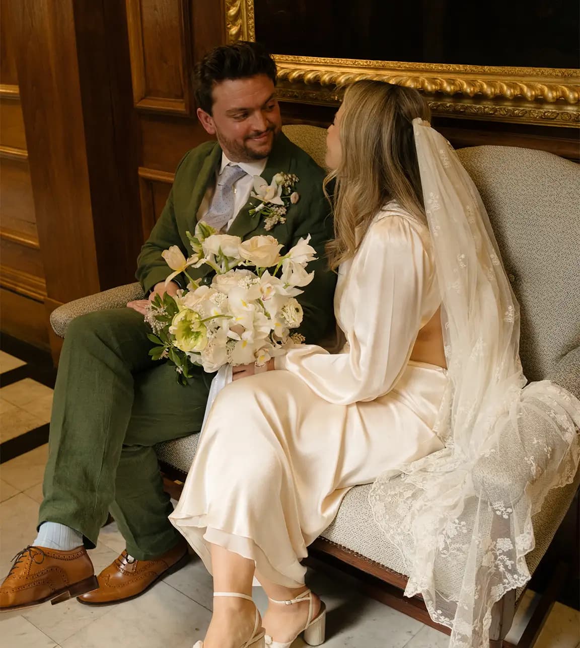 Bride and groom are sitting during their registry office wedding ceremony in Marylebone Town Hall