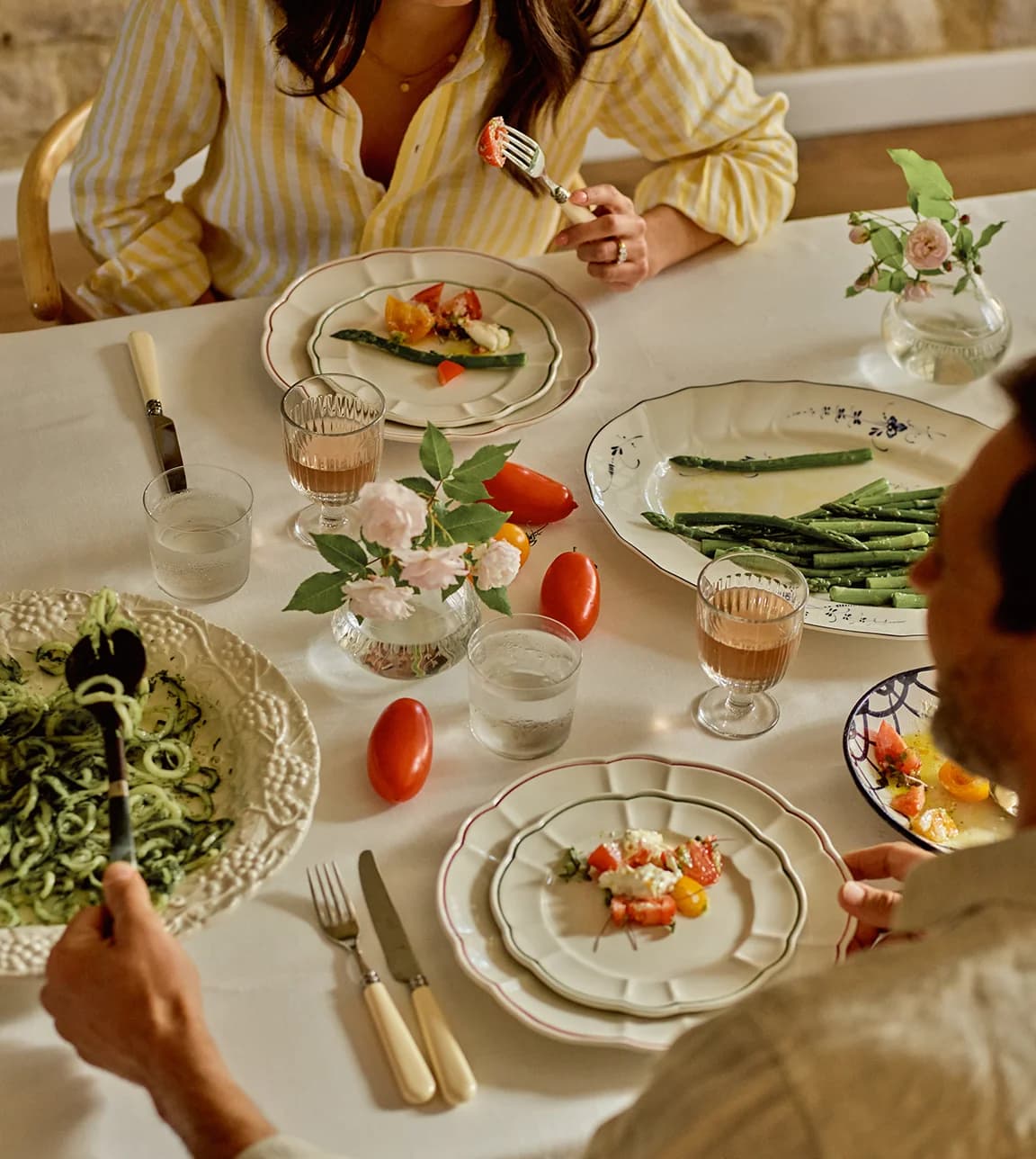Couple enjoying casual table setting with mismatched plates and serveware from 