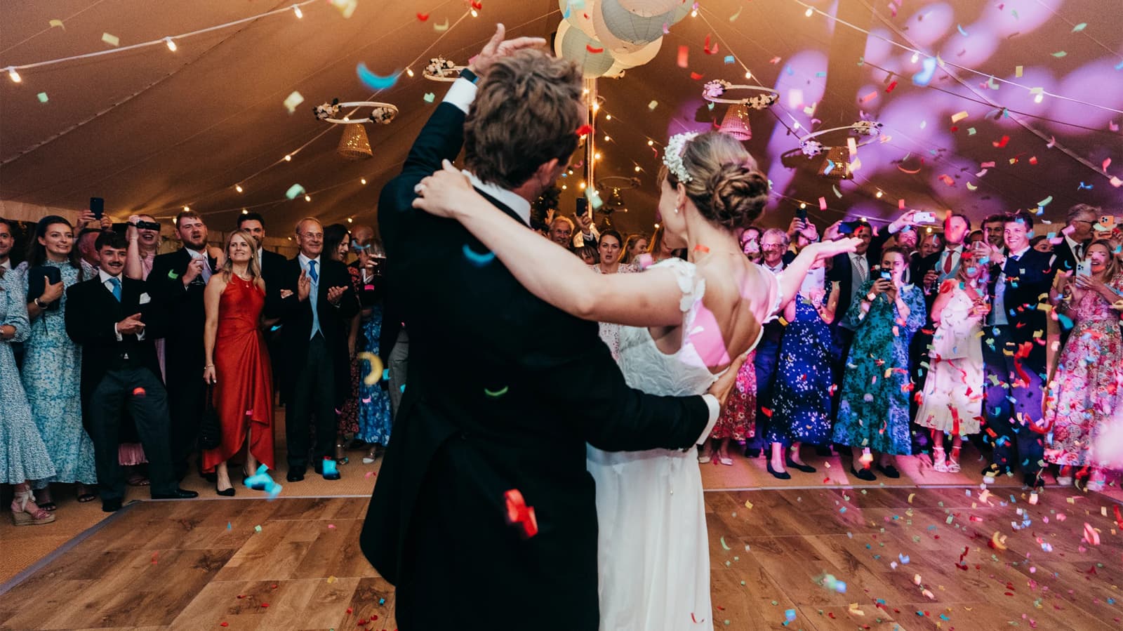 Bride and groom do their first dance with confetti around them