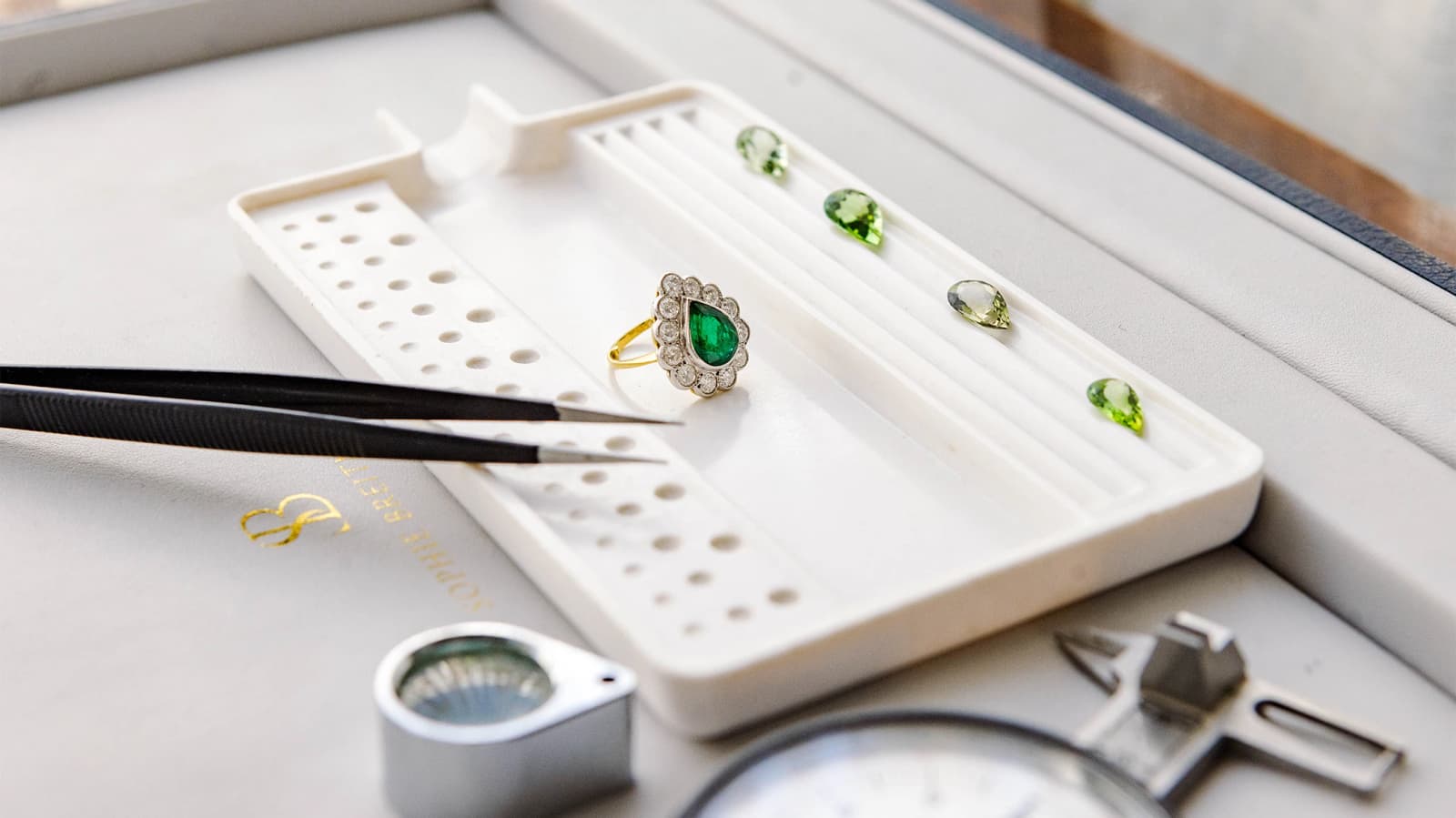 A bespoke emerald engagement displayed on a table