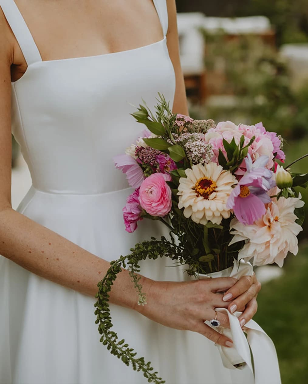 Bride holds a bouquet with wildflowers