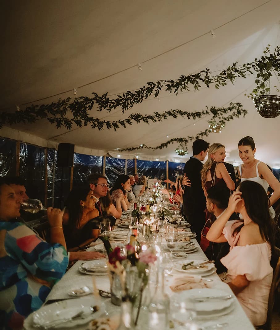 Guests chatting over candlelit tables during the wedding breakfast