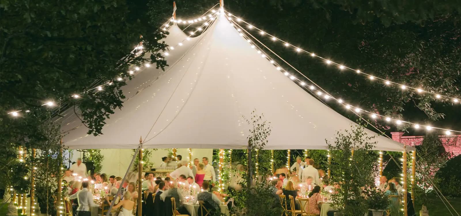 A traditional wedding marquee with festoon lights for English garden inspired wedding in Hampshire.