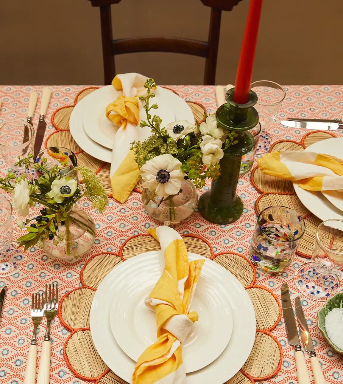 Orange coloured tablescape featuring Rosalyn's wedding presents: crockery, flower vase, striped napkins and terazzo glass tumblers.