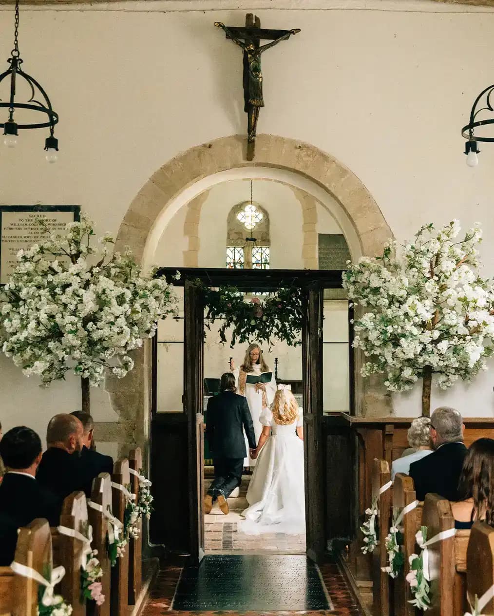 stunning church altar with bride and groom kneeling for wedding ceremony