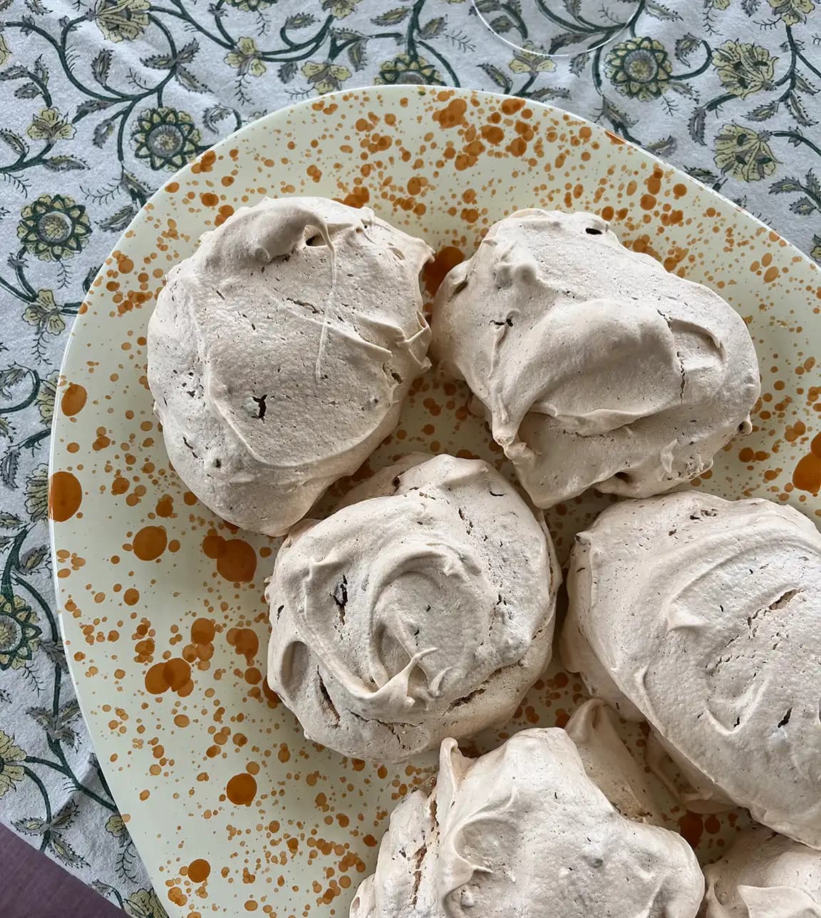Pistachio meringues are being served on a wedding present, a handpainted yellow platter.