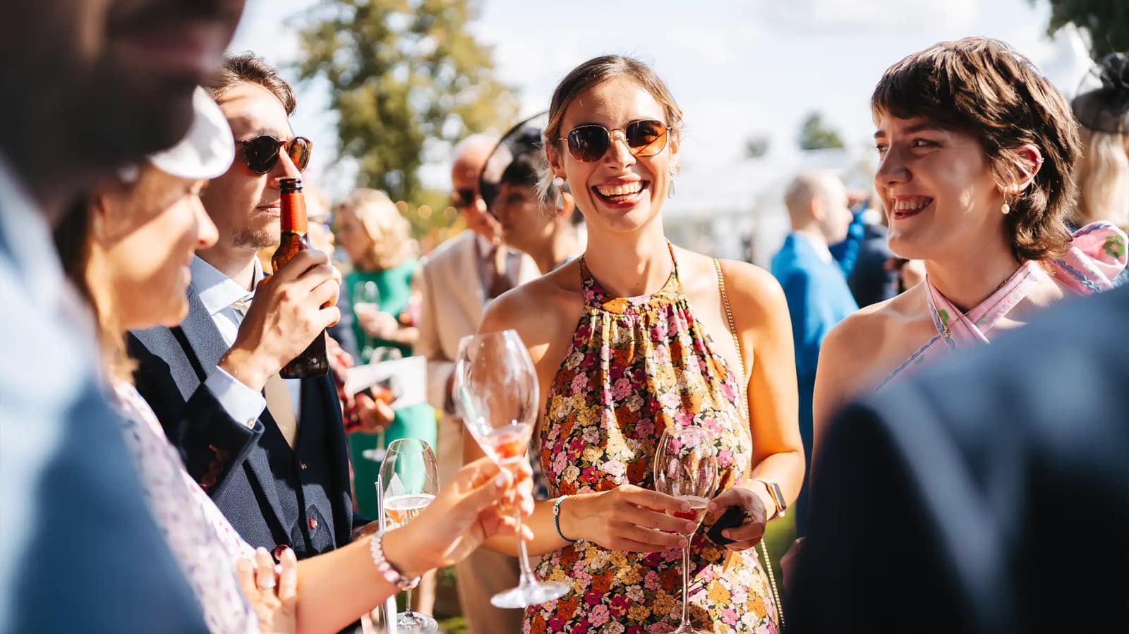 Wedding guests enjoy English sparkling wine at summer wedding.
