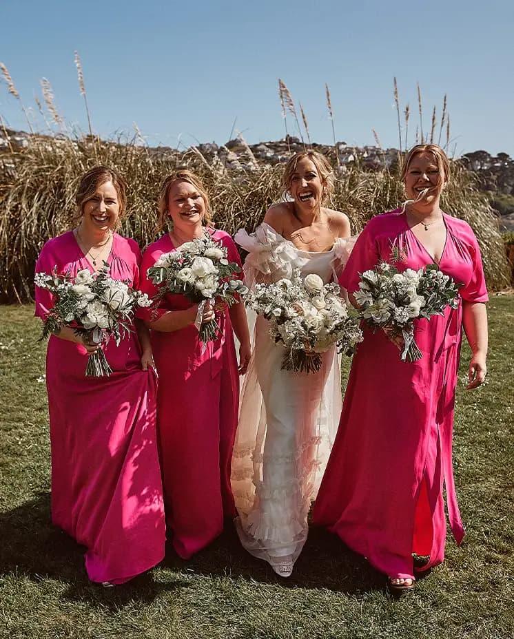 bridesmaids pink dresses flowers sunny Cornwall wedding