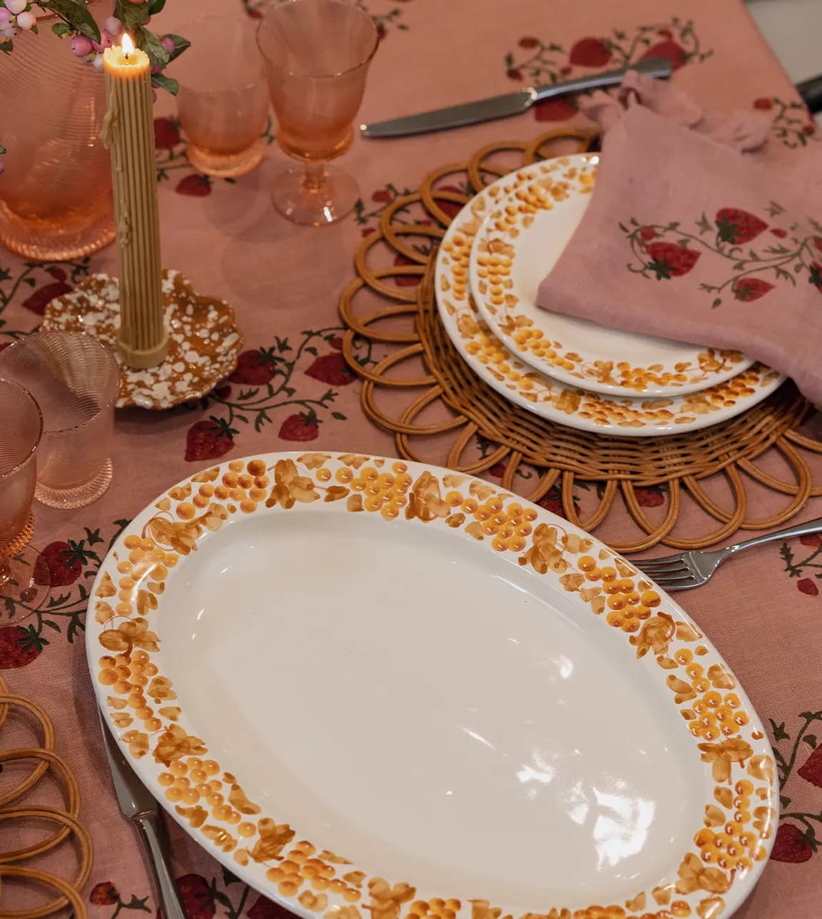 A cosy dinner party tablescape featuring wedding gifts: handpainted plates and platter, coloured glassware and embroidered linen