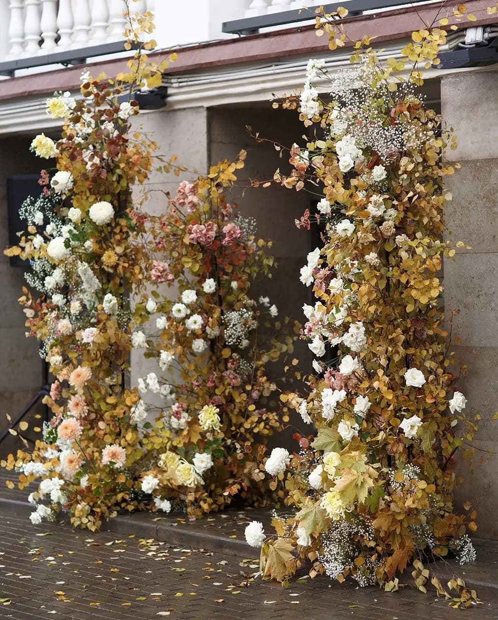 A building front with beautiful autumn wedding flower arch