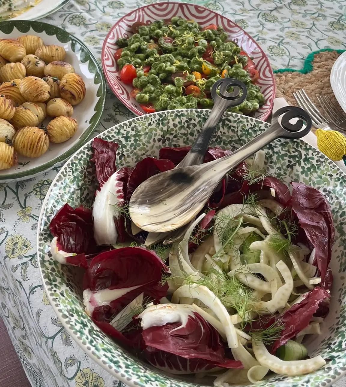 Summer dinner and salads are served on wedding presents, hanpainted platters, placed on floral tablecloth.
