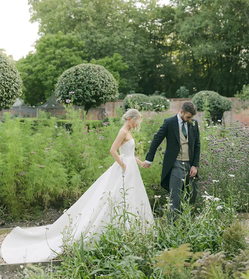 Bride and groom walking in the Hampshire country garden.