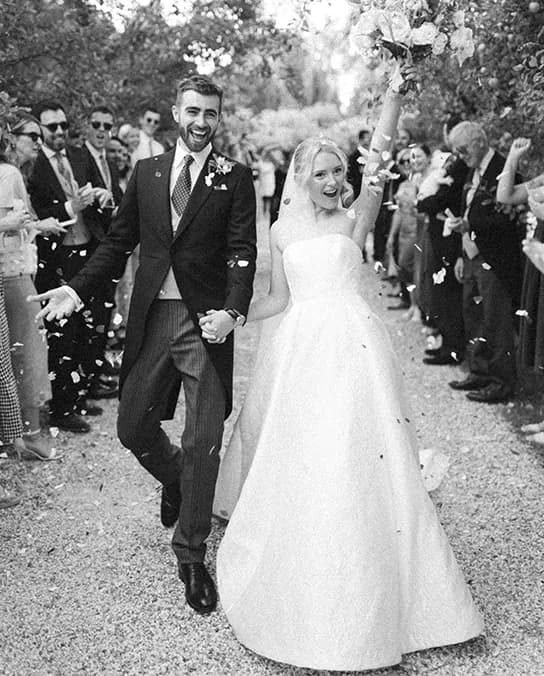 Bride and groom celebrate their English country garden wedding in Hampshire with confetti