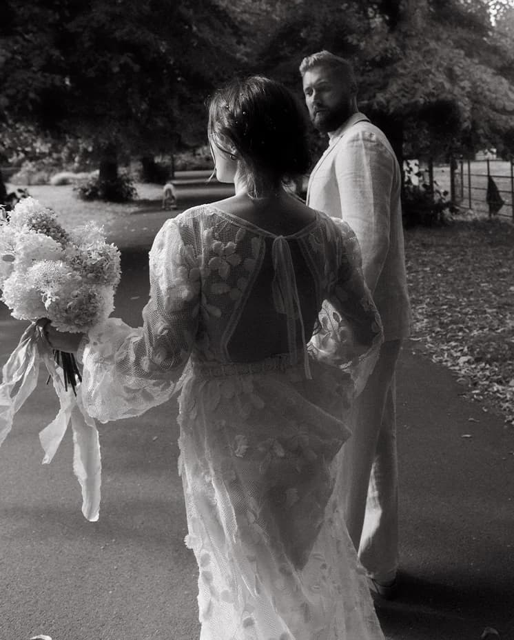 Bride and groom walking with the flower bouquet in their London Park wedding venue