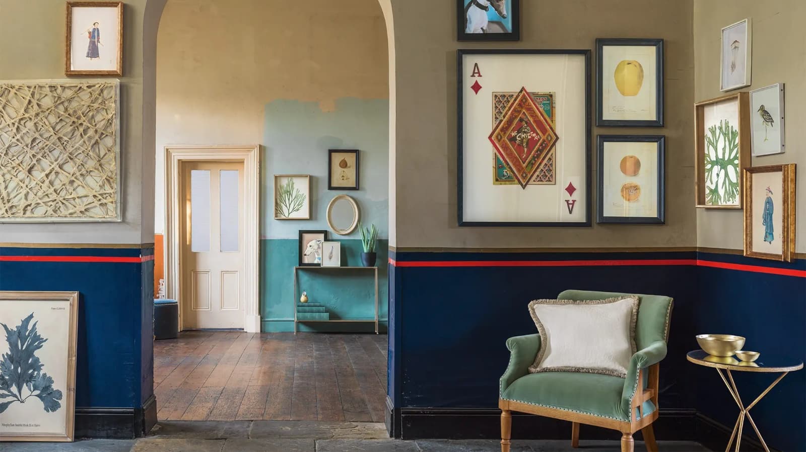 Eclectic gallery wall with mix and matched frames in a colourful hall