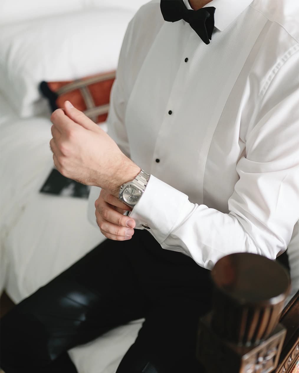 Groom puts on watch while getting ready for wedding ceremony