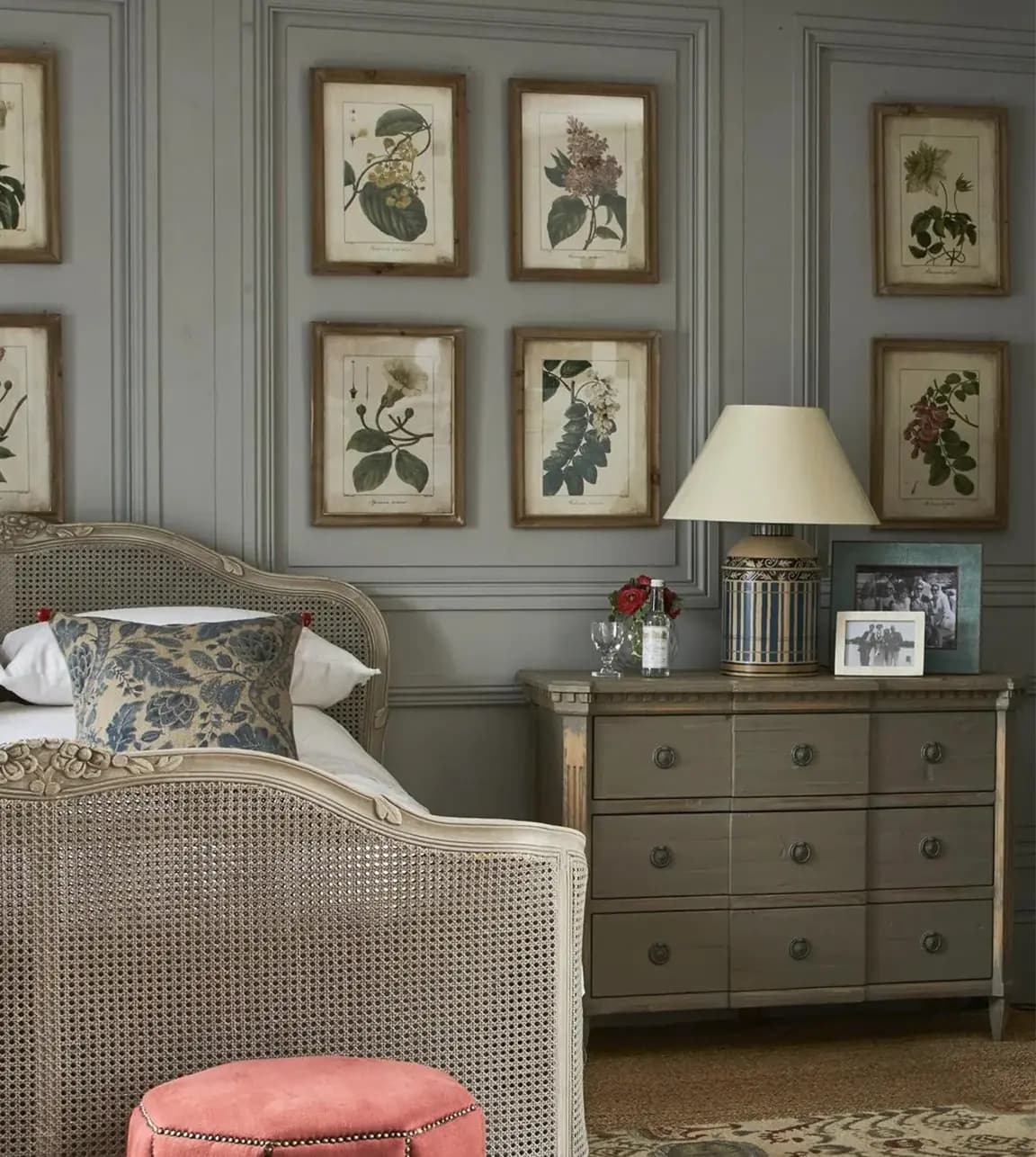 A traditional bedroom interior with gallery wall featuring OKA floral print art.