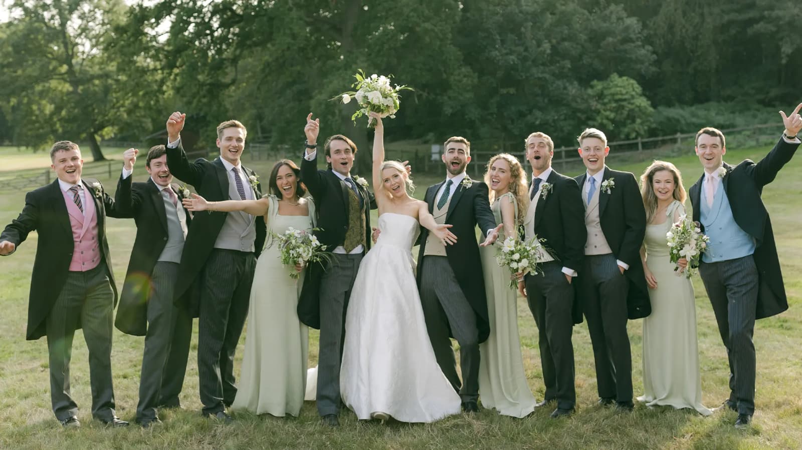 Bride and groom pose for a group wedding portrait with their friends