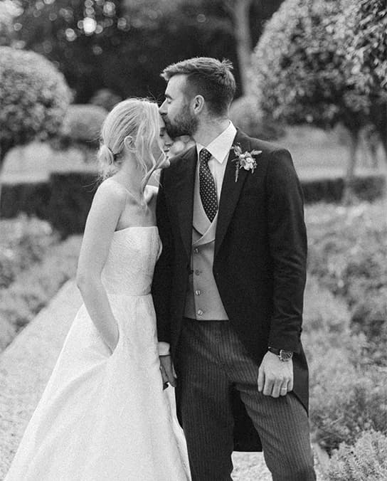 Bride and groom share a tender moment in the garden of their Hampshire country house wedding venue.