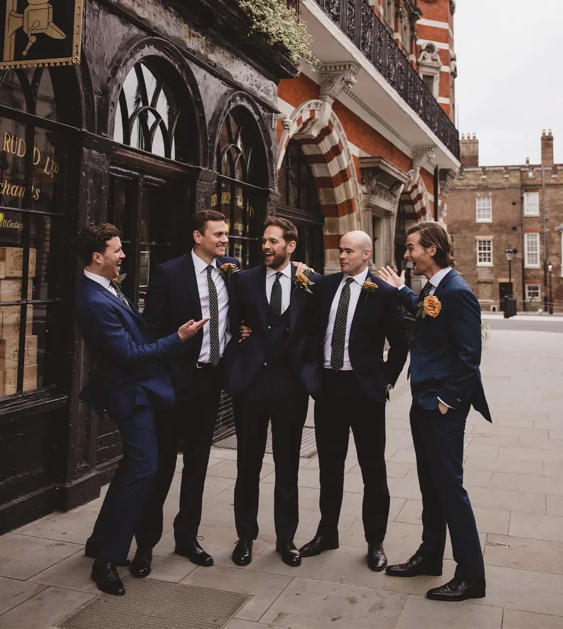 Groomsmen standing outside of London reception venue