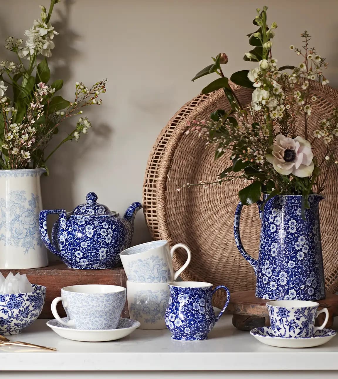Kitchen cupboard displays dark blue Burleigh pottery tableware with ornaments