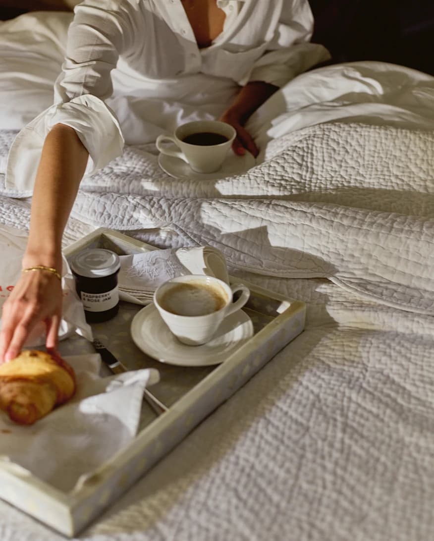 A couple enjoys breakfast in bed using luxury wedding gifts from The Wedding Present Company