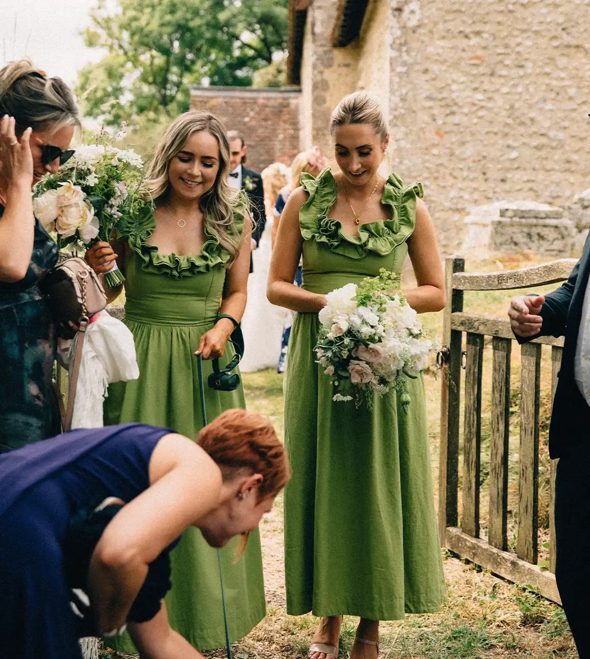 bridesmaids in long green dresses holding bouquets
