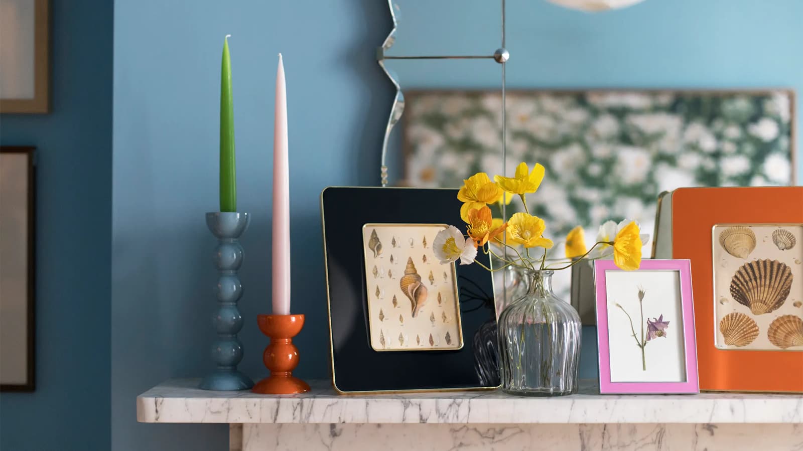 Colourful Addison Ross homeware gifts and candlesticks on a mantel piece