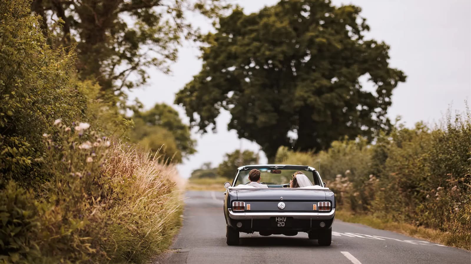 Bride and groom stand out moment convertible car traditional wedding