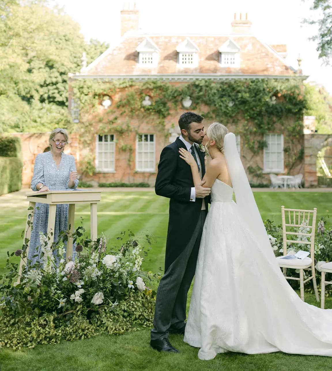 Celebrant gives modern reading during a wedding ceremony in English-style garden