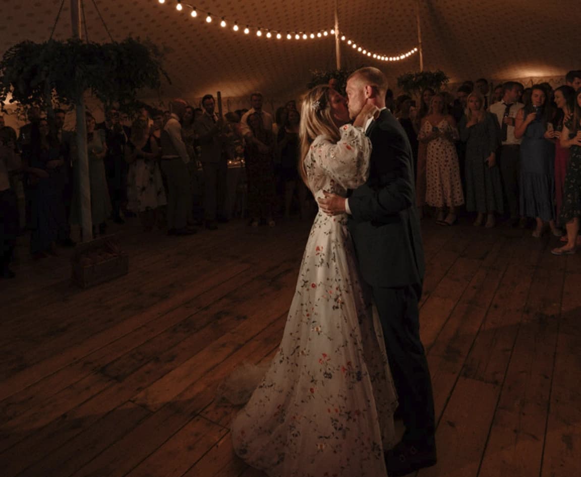 Bride & Groom do a romantic first dance inside marquee with festoon lights.