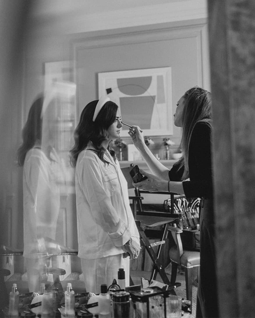 Close-up of the bride getting her wedding makeup done and putting her earrings in