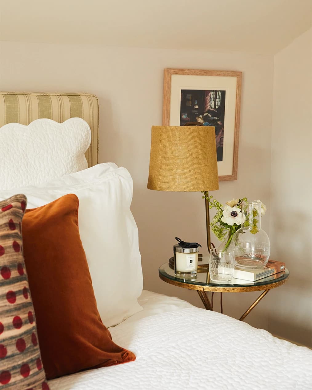 Townhouse bedroom styled with wedding gifts including ochre velvet cushion and bedside with flowers and The Vintage List carafe