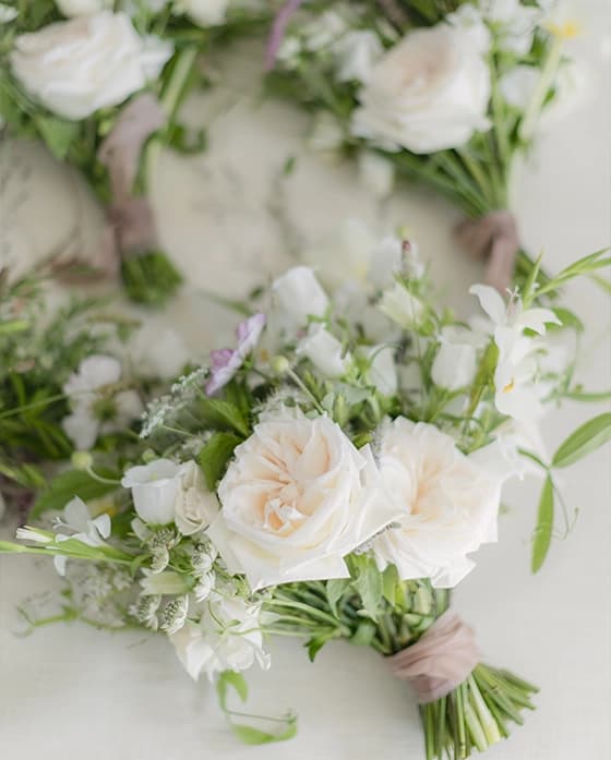 Delicate seasonal wedding bouquet with cream roses and green foliage