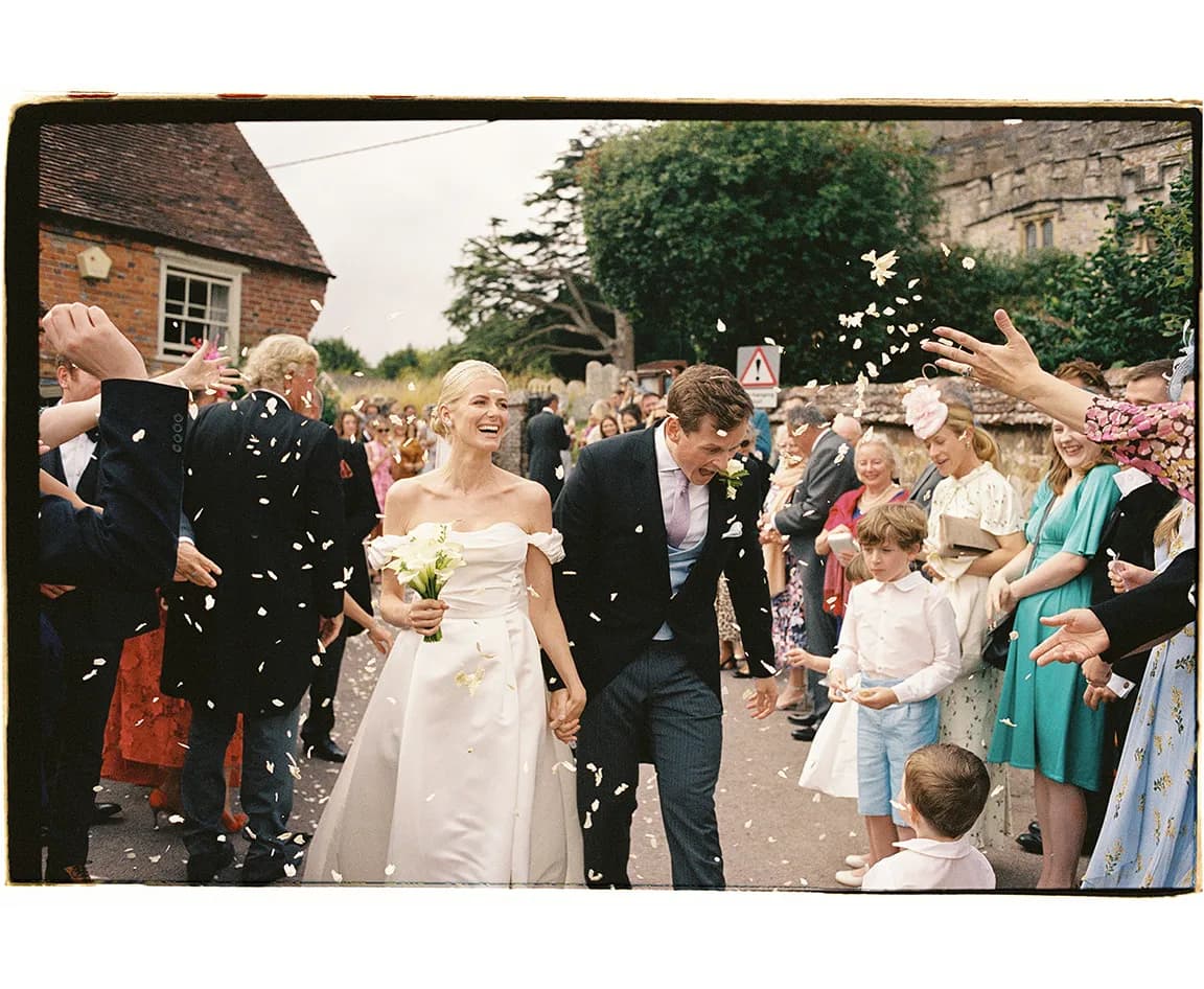 Bride and groom walking together after ceremony while the confetti are being thrown at them