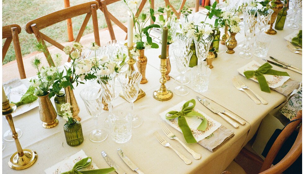 Whimsical Tuscan-Inspired Wedding in Hampshire | Wedding table with Green and white Tuscan-inspired wedding decoration including vintage candleholders and green velvet bows on the placecards
