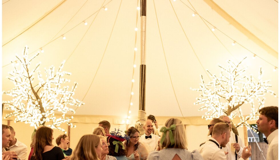 Whimsical Tuscan-Inspired Wedding in Hampshire | Whimsical wedding decoration inside wedding marquee featuring trees with LED lights