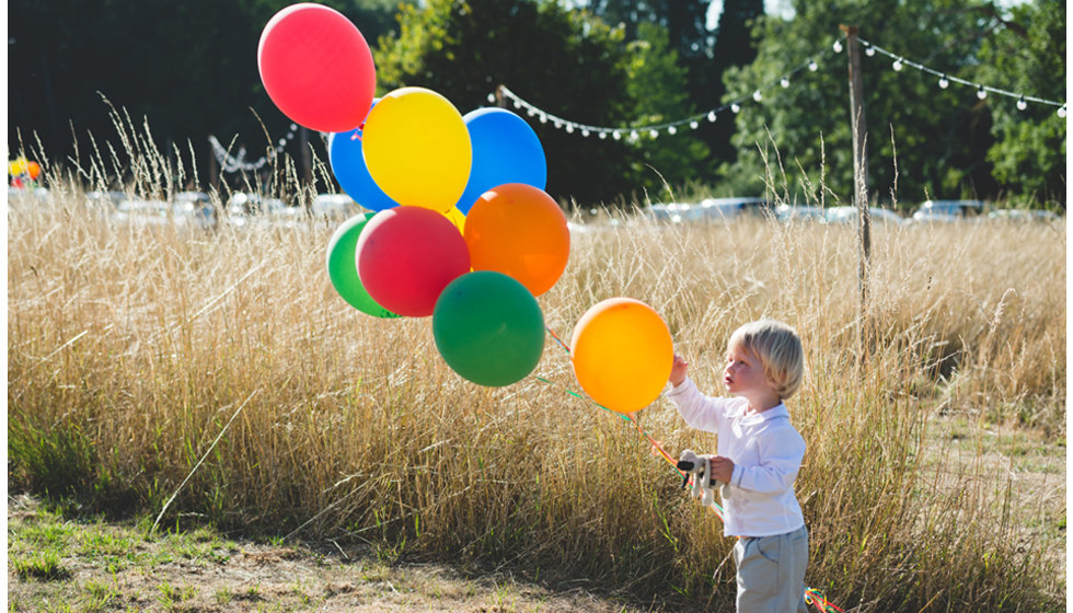 Boy with balloons playing outside during the reception