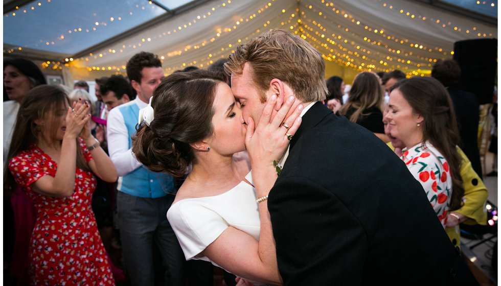 Image showing the couple share a kiss on the dance floor. 