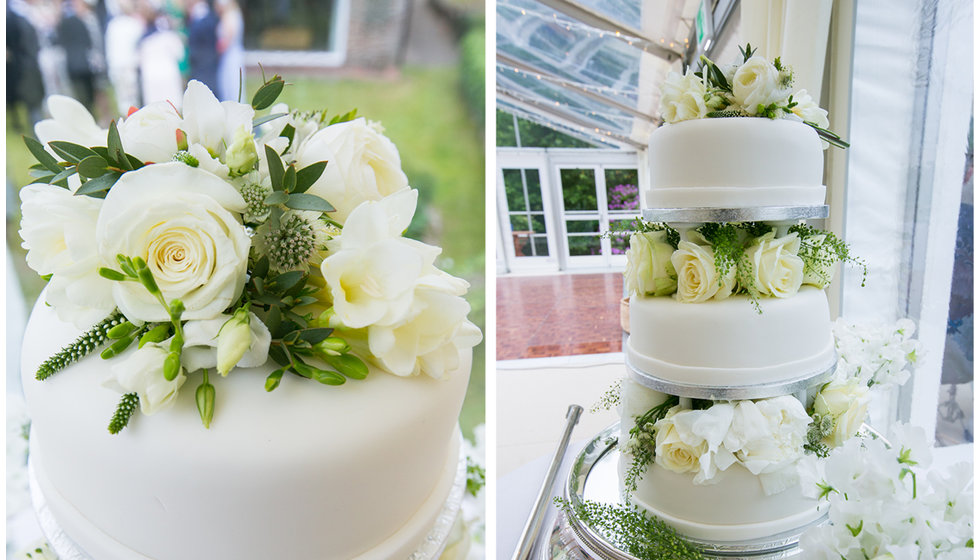 The couple's wedding cake decorated with white royal icing and white roses.