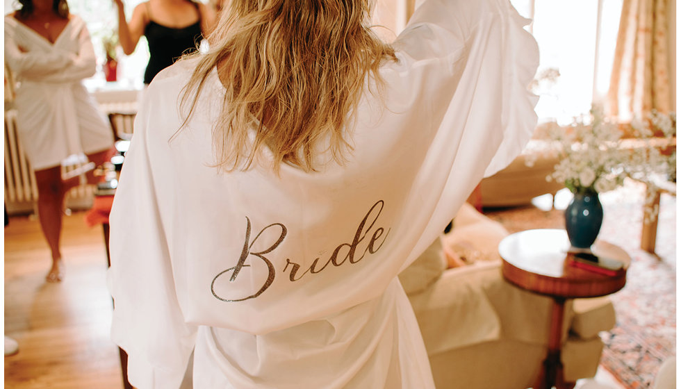 A personalised white dressing gown saying Bride on it.