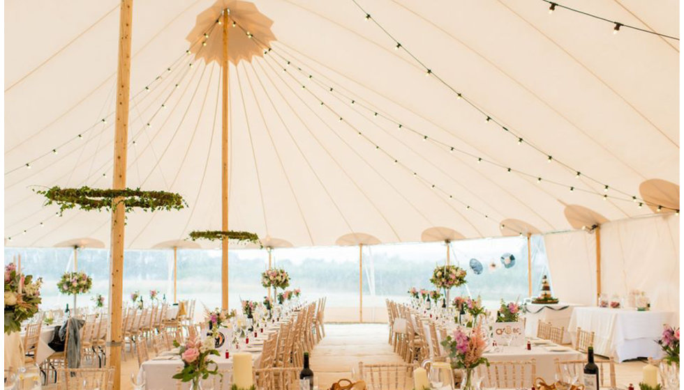 The Papakata tent inside with traditional wooden poles and festoon lights. 