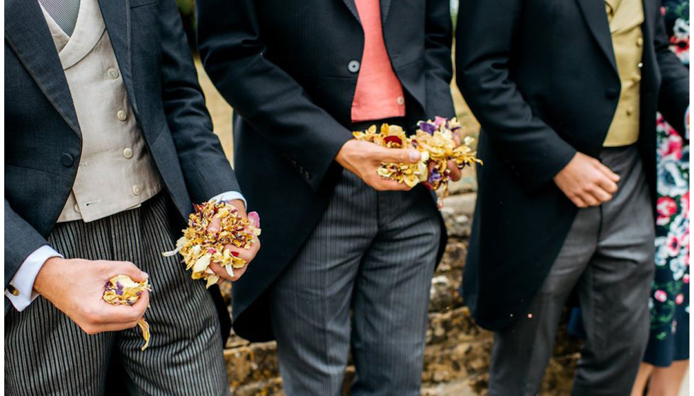 Ushers holding hand fulls of dried confetti.