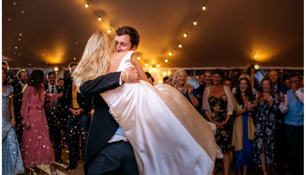 The couple embrace on the dance floor during their first dance.