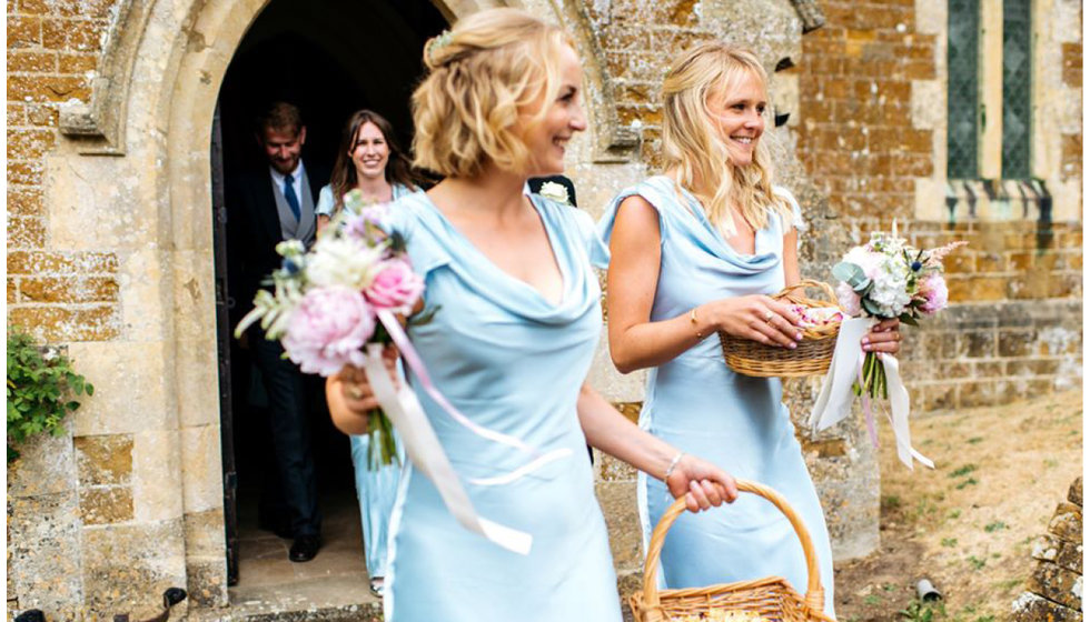 The bridesmaids holding baskets of confetti outside the church.