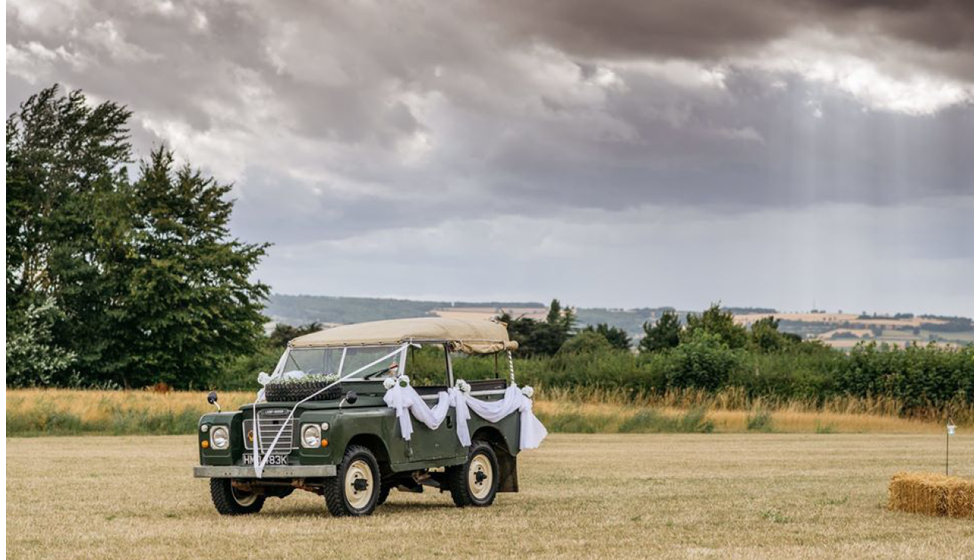 The vintage Land Rover that served as the couples wedding car decorated with bows and ribbons.