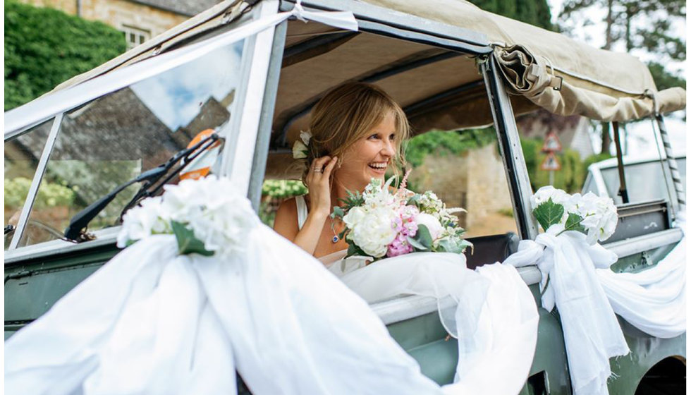 Jo sitting in the specially decorated land rover with ribbons and flowers.