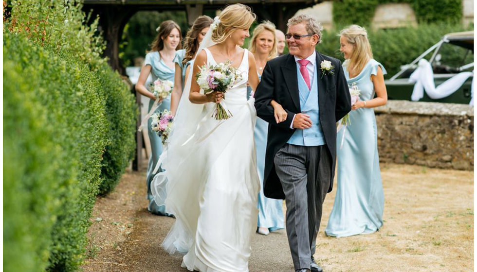 The bride and her father walking to the church showing her beautiful Le Spose Di Gio dress. 