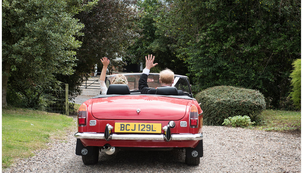 Bride Lizzie and her father in a vintage MG on the way to the Church.